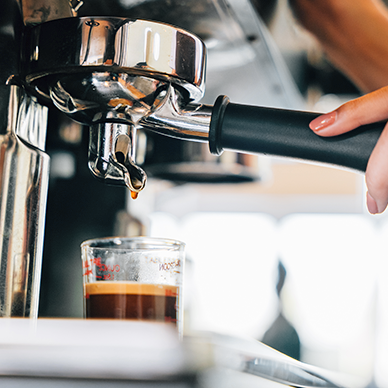 Espresso machine brewing coffee cup